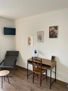 Habitación con mesa, silla y escritorio. en Au Clos Decoeur, en Salaise-sur-Sanne
