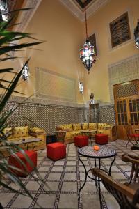 a living room with couches and tables and a chandelier at Riad Diamant De Fes in Fez