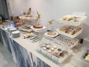 ein Tisch mit vielen Tabletts mit verschiedenen Sorten Donuts. in der Unterkunft Hotel Concorde Fiera in Saronno