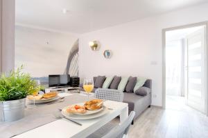 Biały salon ze stołem i kanapą w obiekcie Tyzenhauz Apartments Piwna Street w Krakowie