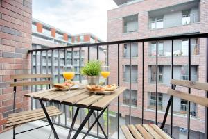 a balcony with a table and two glasses of wine at Tyzenhauz Apartments Piwna Street in Krakow