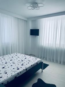 Schlafzimmer mit einem Bett mit weißen Vorhängen in der Unterkunft Oble Apartament's center in Craiova