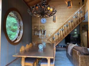 jadalnia ze stołem i żyrandolem w obiekcie Family Chalet, Stunning Views & New Hot Tub w mieście La Côte dʼArbroz