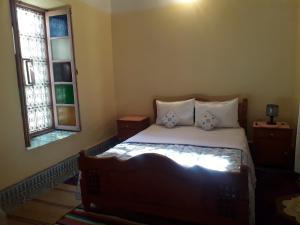 ein Schlafzimmer mit einem Bett und zwei Fenstern in der Unterkunft Écologie oasis tafilalt CHEZ L' HABITANT in Er Rachidia