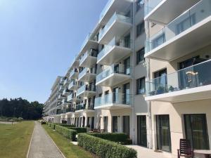 ein Apartmenthaus mit Balkon und Bürgersteig in der Unterkunft Prora Strand Appartement in Binz