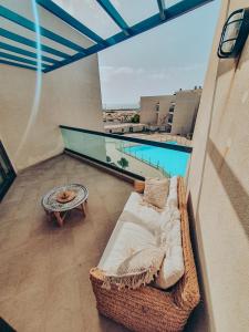 Balcón con sofá, mesa y piscina en Casa Aloe Vera en El Cotillo