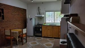 a kitchen with a table and chairs and a brick wall at Rowina Inn 1 in Tigre