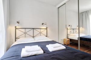 a bedroom with a large bed with two towels on it at Tyzenhauz Apartments Piwna Street in Krakow