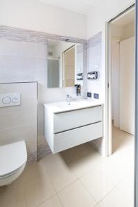 bagno con lavandino bianco e servizi igienici di Villa Cisa con yacuzzi a Lignano Sabbiadoro