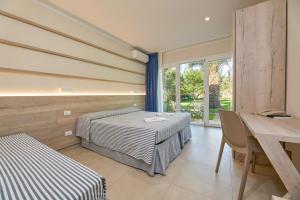 a bedroom with two beds and a table and a table and chairs at Hotel Villa Rodriguez in Capoliveri