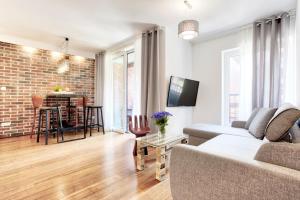 a living room with a couch and a brick wall at Tyzenhauz Apartments Piwna Street in Krakow