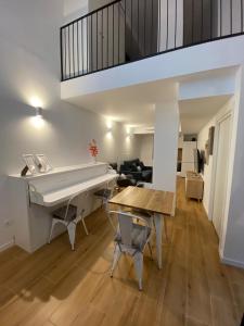 a kitchen and living room with a table and a piano at Travel Habitat Alameda Suites. in Valencia