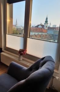 een woonkamer met een bank voor een raam bij Centar view lux in Novi Sad