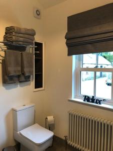 baño con aseo, ventana y radiador en Rectory Cottage. Close to Enniskillen and lakes., en Enniskillen