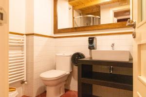 a small bathroom with a toilet and a sink at Casa Rural Yoruba in Amés