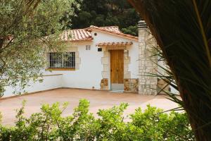 a small white house with a wooden door at Private Apartments Cala Canyelles in Lloret de Mar