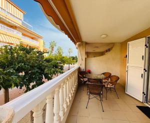 balcón con mesa y sillas en Beachfront apartment with a private garden on the ground floor, en Moncófar