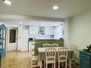 cocina y comedor con mesa y sillas en Beachfront apartment with a private garden on the ground floor, en Moncófar