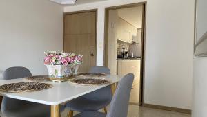 una mesa de comedor con sillas y un jarrón de flores en 3 Habitaciones, hermoso apartamento, exelente ubicacion en el sur de Cali, en Cali