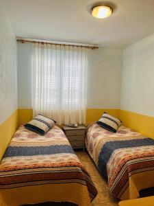 1 dormitorio con 2 camas y ventana en Beachfront apartment with a private garden on the ground floor, en Moncófar