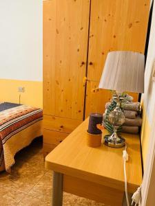 Un dormitorio con una mesa con una lámpara. en Beachfront apartment with a private garden on the ground floor, en Moncófar