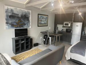 a kitchen and living room with a couch and a table at 28 on Symonds Luxstudio 5 in George