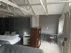 a bedroom with a bed and a desk and a chair at 28 on Symonds Luxstudio 5 in George +27 photos