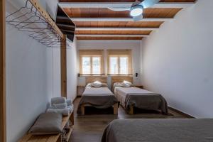a room with three beds and a window at Cal Xot in Poblenou del Delta