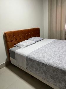 a bed with a brown headboard in a bedroom at Fazenda Alto Alegre in Piumhi