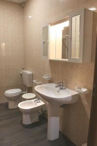 a bathroom with a sink and a toilet and a mirror at Adams Rooms - Affittacamere in San Giovanni Lupatoto