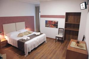 a bedroom with a bed and a desk and a chair at Adams Rooms - Affittacamere in San Giovanni Lupatoto