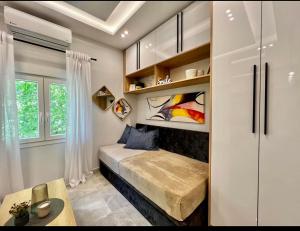 um pequeno quarto com uma cama e uma janela em ARES SUITE em Tessalônica
