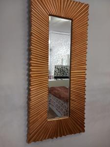 a mirror with a wooden frame on a wall at Suite con Jacuzzi de la Haya, junto al Teatro Romano in Merida