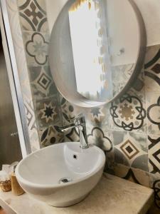 a white sink sitting under a mirror in a bathroom at Casa Bea B&B in Tortolì