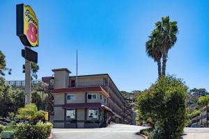 a building with a palm tree in front of it at Super 8 by Wyndham San Diego Hotel Circle in San Diego