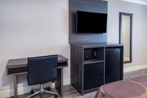 a room with a desk with a computer and a television at Super 8 by Wyndham North Hollywood in North Hollywood