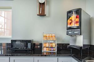 a kitchen with a microwave and a refrigerator with food at Super 8 by Wyndham North Hollywood in North Hollywood