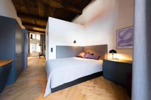 um quarto com uma grande cama branca e pisos em madeira em TORhaus Appartments Sendenhorst em Sendenhorst