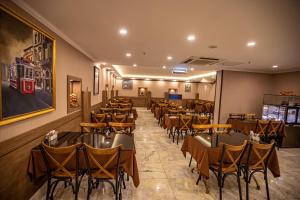 Hamitbey Hotel Yenikapı في إسطنبول: مطعم فيه طاولات وكراسي في الغرفة