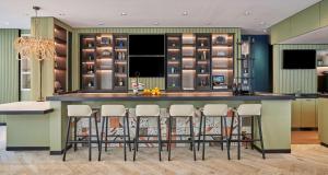 uma cozinha com um bar com bancos à volta em Hyatt Centric the Pike Long Beach em Long Beach