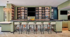a kitchen with a bar with stools around it at Hyatt Centric the Pike Long Beach in Long Beach