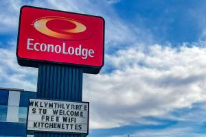a sign on a pole with a colombiaospel sign on it at Econo Lodge Motel Village in Calgary