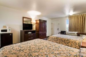 a hotel room with two beds and a television at Econo Lodge Bartlesville Hwy 75 in Bartlesville +15 photos