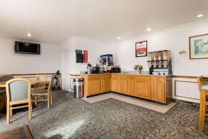 a kitchen with wooden cabinets and a table and a dining room at Econo Lodge Bartlesville Hwy 75 in Bartlesville