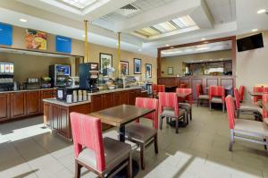 un restaurante con sillas rojas, una mesa y una barra en Comfort Inn Blacksburg University Area, en Blacksburg