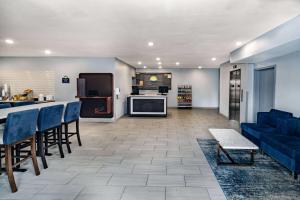 un soggiorno con divano blu e una cucina di Days Inn & Suites by Wyndham Horn Lake - Memphis Graceland a Horn Lake