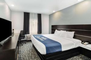 Habitación de hotel con cama y escritorio en Days Inn & Suites by Wyndham Horn Lake - Memphis Graceland en Horn Lake