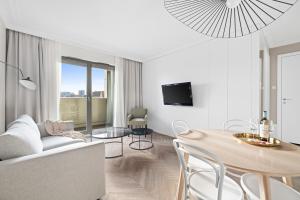 un soggiorno bianco con tavolo e divano di GREAT Grano Residence a Danzica