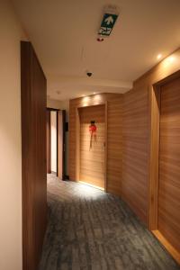 a hallway with wooden walls and a person jumping out of a door at Woodside TEA Residences & SPA Kopaonik in Kopaonik