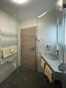 y baño con lavabo y ducha acristalada. en Landgasthof Kanz en Tanna